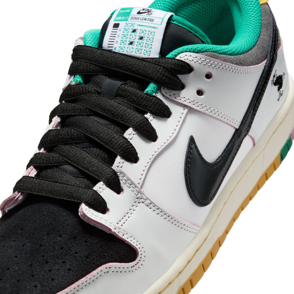 Close-up of the NIKE SB X CSEF DUNK LOW SUMMIT WHITE/BLACK-WHITE-IRON GREY by nike, showcasing black laces, black and white panels, green inner lining, patent leather Swoosh, gum sole, and a visible bird graphic on the heel.