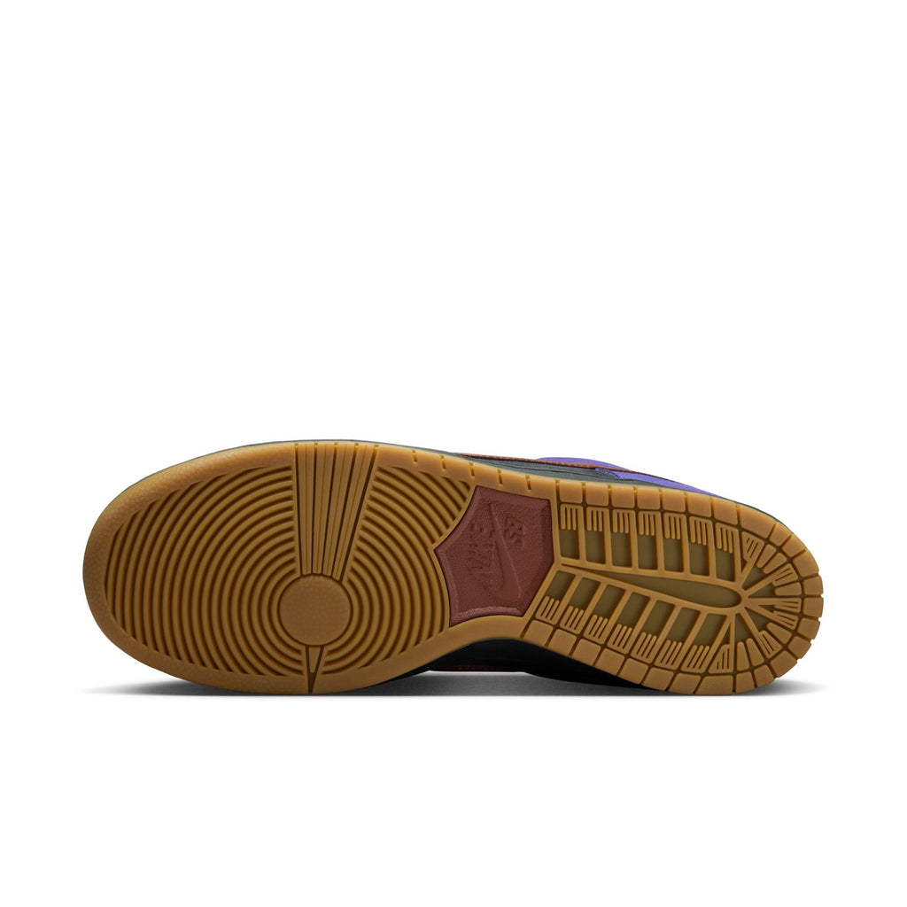 The image shows the sole of the NIKE SB DUNK LOW PRO PERSIAN VIOLET / OFF NOIR by nike, featuring a gum-colored outsole with circular and wavy tread patterns, plus a branded Bluetile Skateboards-inspired section in the center.