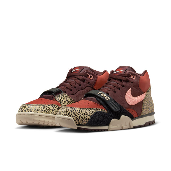Pair of nike SB x Arts-Rec Air Trainer 1 in Limestone/Pink Quartz/Earth/Dusty Peach/Black/Desert Sand with animal print panels, pink Swoosh, Velcro strap, and beige sole displayed on a white background.