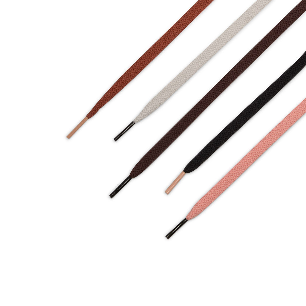 Four flat shoelaces in brown, white, dark brown, and pink are displayed diagonally—ideal for adding style to your nike NIKE SB X ARTS-REC AIR TRAINER 1 LIMESTONE/PINK QUARTZ-EARTH-DUSTY PEACH-BLACK-DESERT SAND sneakers.