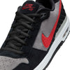 Close-up of the NIKE SB P-ROD 1 ZOOM AIR LOW BLACK / VARSITY RED-FLINT GREY-BLACK by Nike, Paul Rodriguez's signature shoe, with a red swoosh, black laces, black and flint grey suede panels, and visible Zoom Air cushioning.
