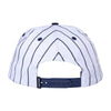 Back view of the Carpet Co. VENTURE X BRONZE 56K PINSTRIPE HAT, a white trucker hat with black pinstripes, featuring an adjustable blue strap and a subtle black screen-printed logo.