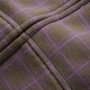 Close-up of the BUTTER ERUPTION ZIP-THRU HOODIE PLAID by Butter Goods, featuring brown fabric with a purple plaid pattern, intersecting seams, and detailed stitching for a cozy fleece finish.