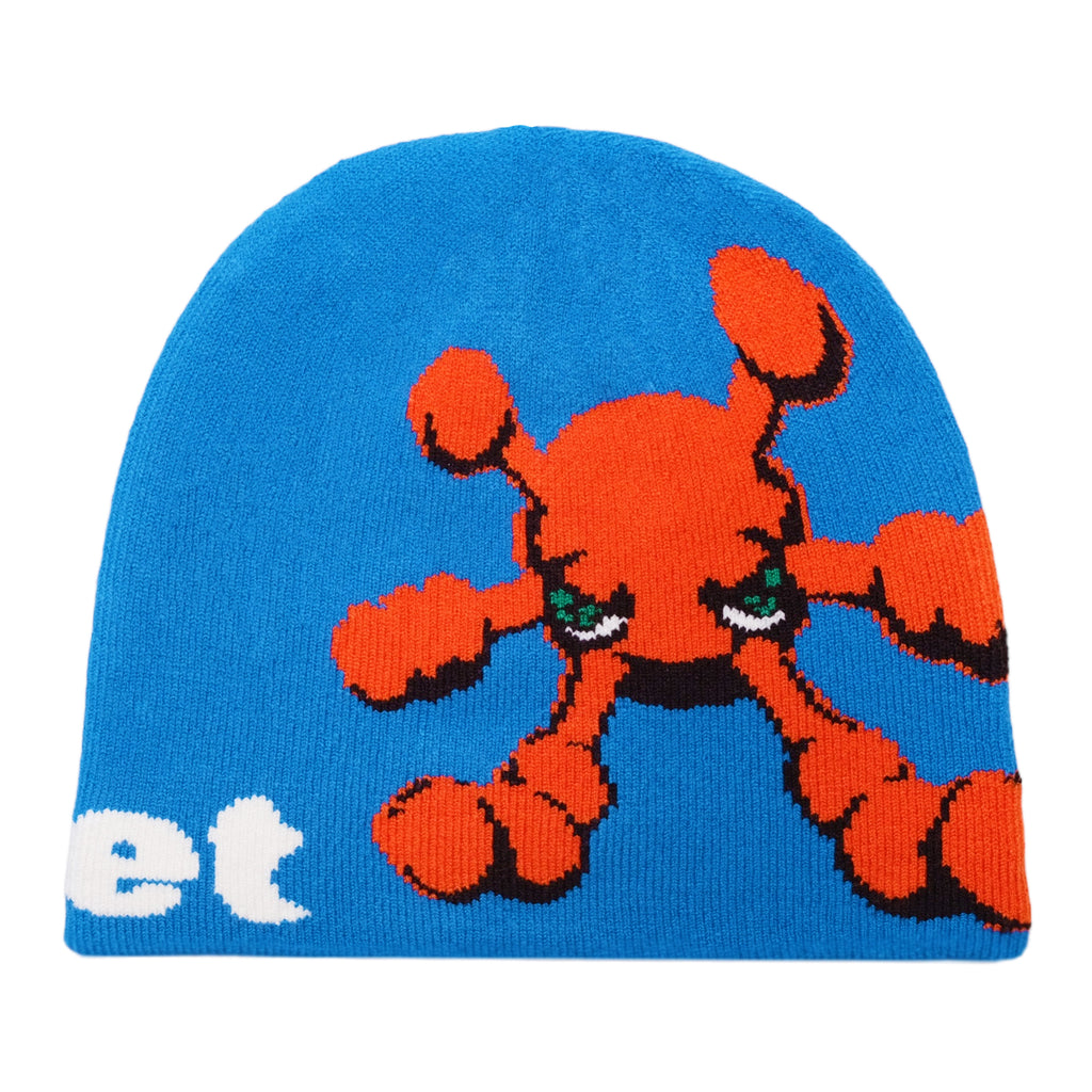 The blue CARPET CO. BACTERIA REVERSIBLE BEANIE by Carpet Co. features an orange cartoon character with green eyes and the partial text "et" on the left side, branded with a subtle BEANIE GREEN tag.