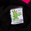Close-up of a cotton clothing label featuring a green figure and text: "CARPET CO. BRAT film by Carpet Co. brought to you by the habibis at Carpet Co.