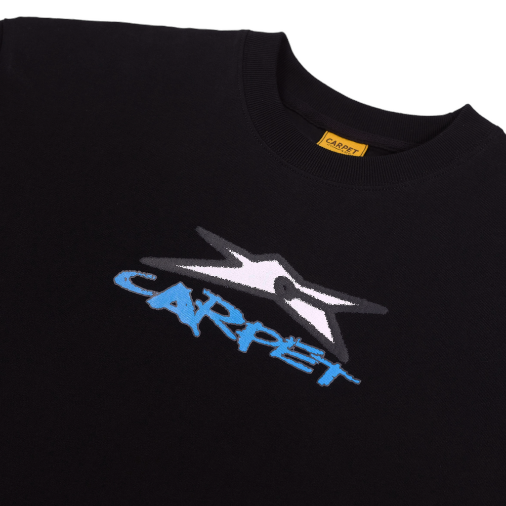 A close up of the black tee with the star carpet logo in white and the word "Carpet" in blue under it.