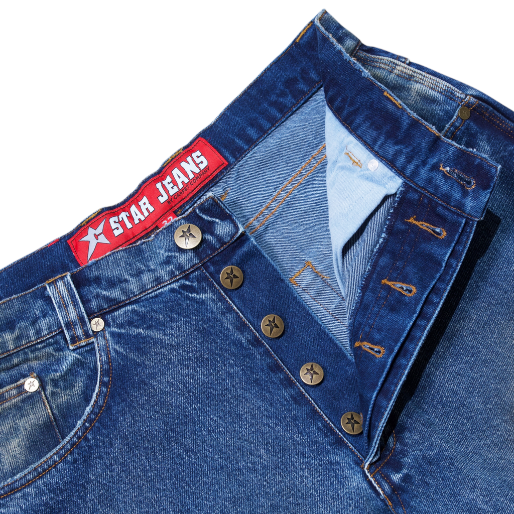 Close-up of washed blue CARPET CO. C-STAR jeans by POLAR, featuring a visible button fly and "Star Jeans" label on the cotton waistband.