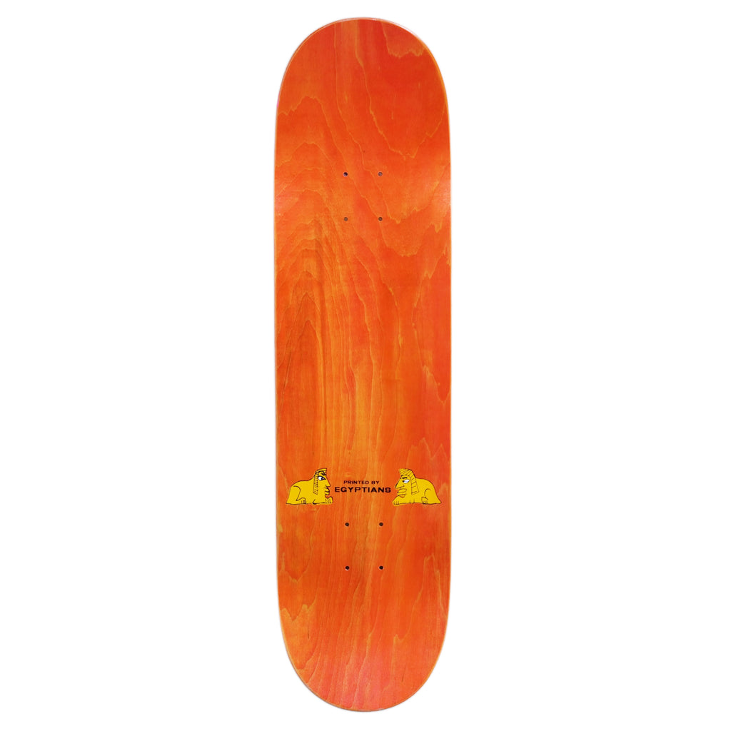 A skateboard deck called CARPET EGYPT GREEN by Carpet Co., showcasing an orange wood grain finish with a hand-screened small cartoon graphic near the center-bottom.