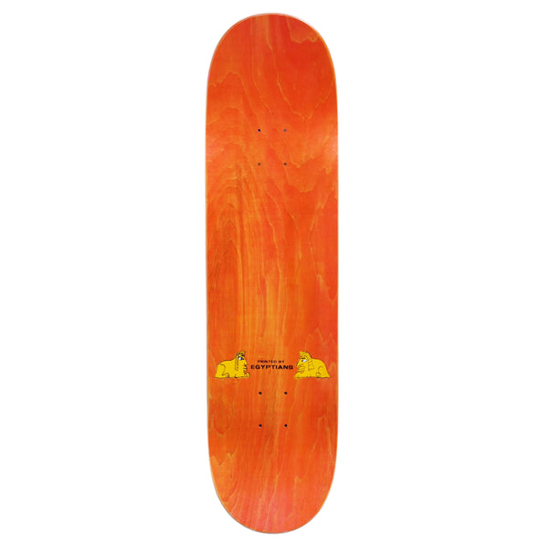 A skateboard deck called CARPET EGYPT GREEN by Carpet Co., showcasing an orange wood grain finish with a hand-screened small cartoon graphic near the center-bottom.