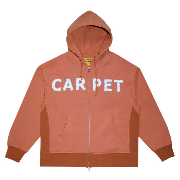 Dusty brown hoodie from Carpet Co. with "Carpet Company" in white, featuring a logo zip style, a green double zip, and two front pockets.