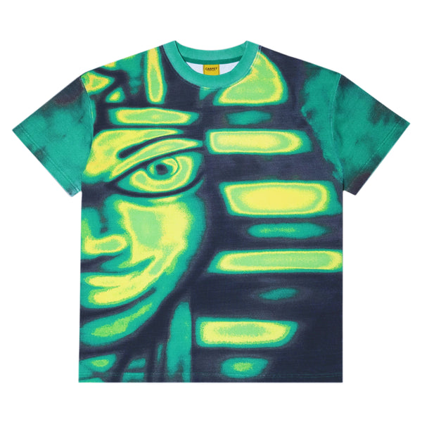 Introducing the CARPET CO. EGYPT TEE GREEN by Carpet Co. This vibrant tee features a striking green and yellow abstract face design on a dark background, embodying bold artistry and making it a standout piece for any wardrobe.