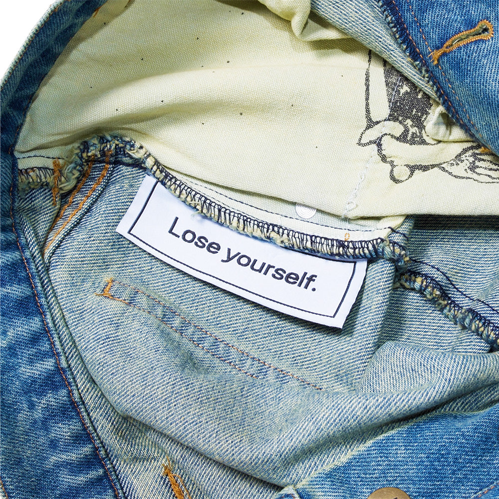 Close-up of the inside of CARPET CO. C STAR FADED DENIM SHORTS by Carpet Co., showing a "Lose yourself." label sewn onto the inner lining.