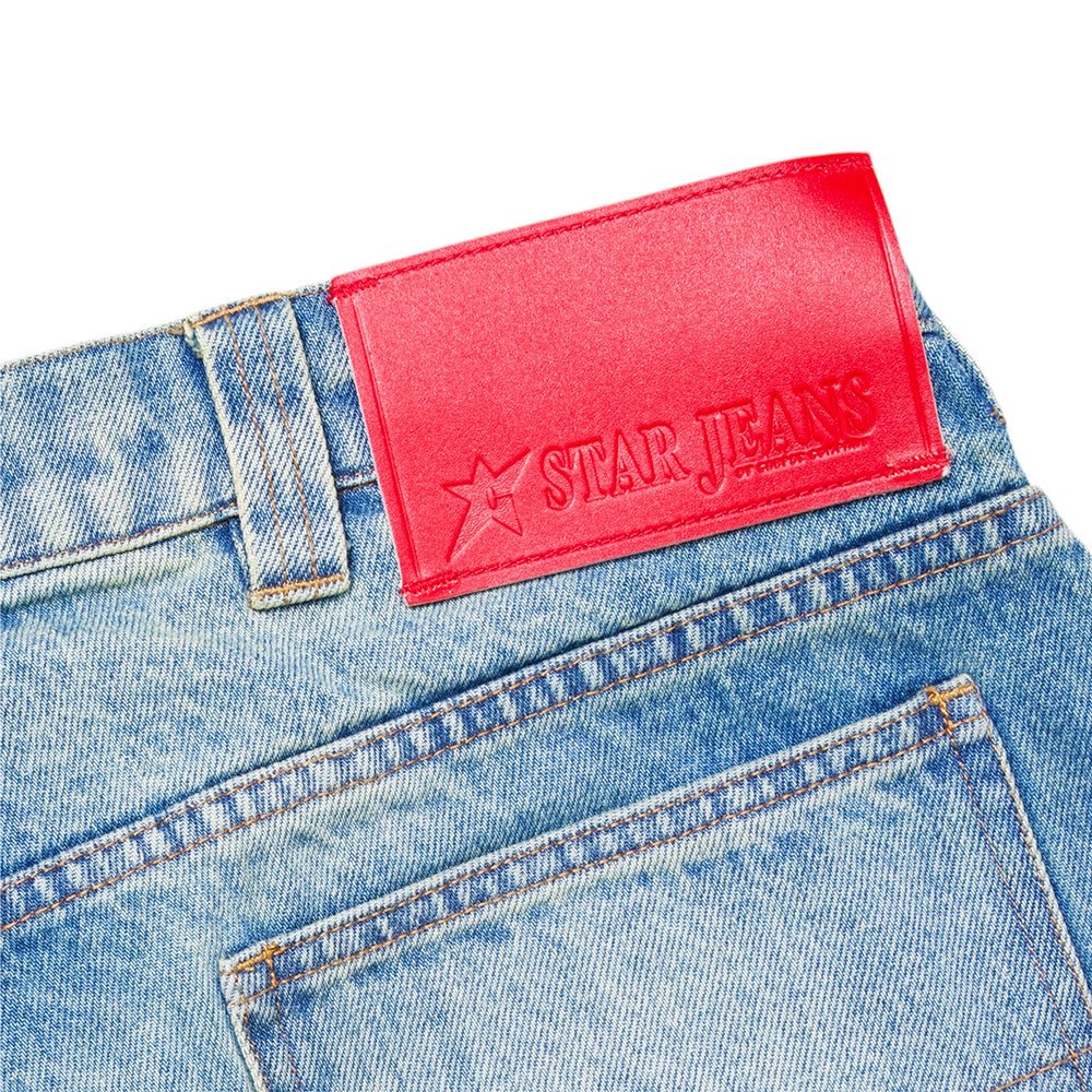 Close-up of the back pocket and waistband of Carpet Co. C Star Faded Denim Shorts, light blue, featuring a red leather patch labeled "STAR JEANS.