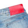 Close-up of the back pocket and waistband of Carpet Co. C Star Faded Denim Shorts, light blue, featuring a red leather patch labeled "STAR JEANS.