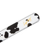 A black and white cow print LOOSEY MOOSEY BELT with gold lettering and a gold buckle.