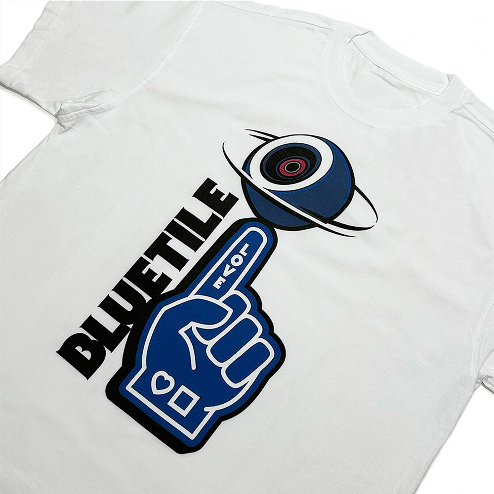 The *PRE-ORDER* BLUETILE NAVY FOAM FINGER TEE WHITE by Bluetile Skateboards is a white 100% cotton tee with a graphic of a blue hand pointing to a stylized camera icon, featuring "BLUETILE" beside the design.