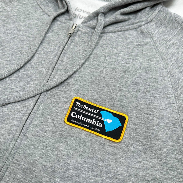 A BLUETILE HEART OF COLUMBIA PATCH ZIP HOODIE GREY with a patch that says Columbia. (Brand: Bluetile Skateboards)