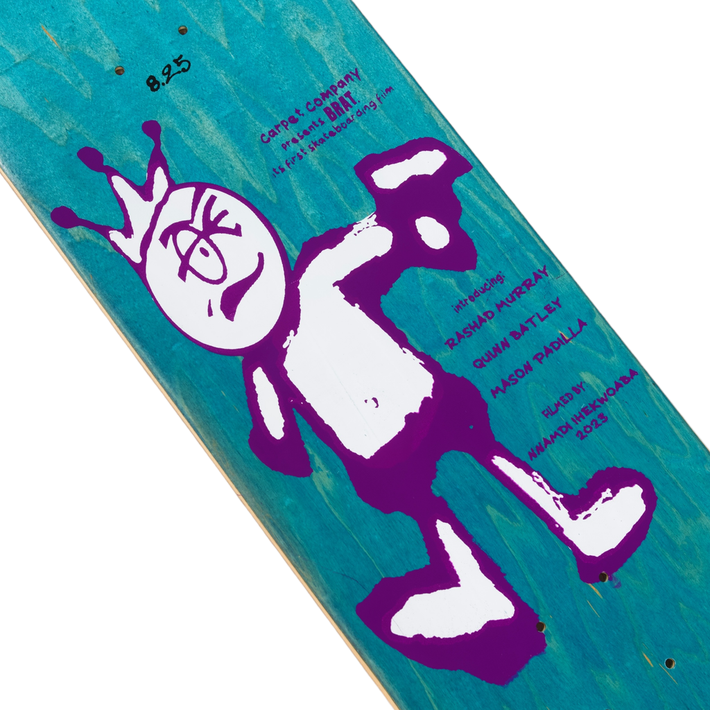Purple and white screen-printed illustration of the Carpet Co. Brat Logo cartoon character on a teal Carpet Co. skateboard deck with signatures.