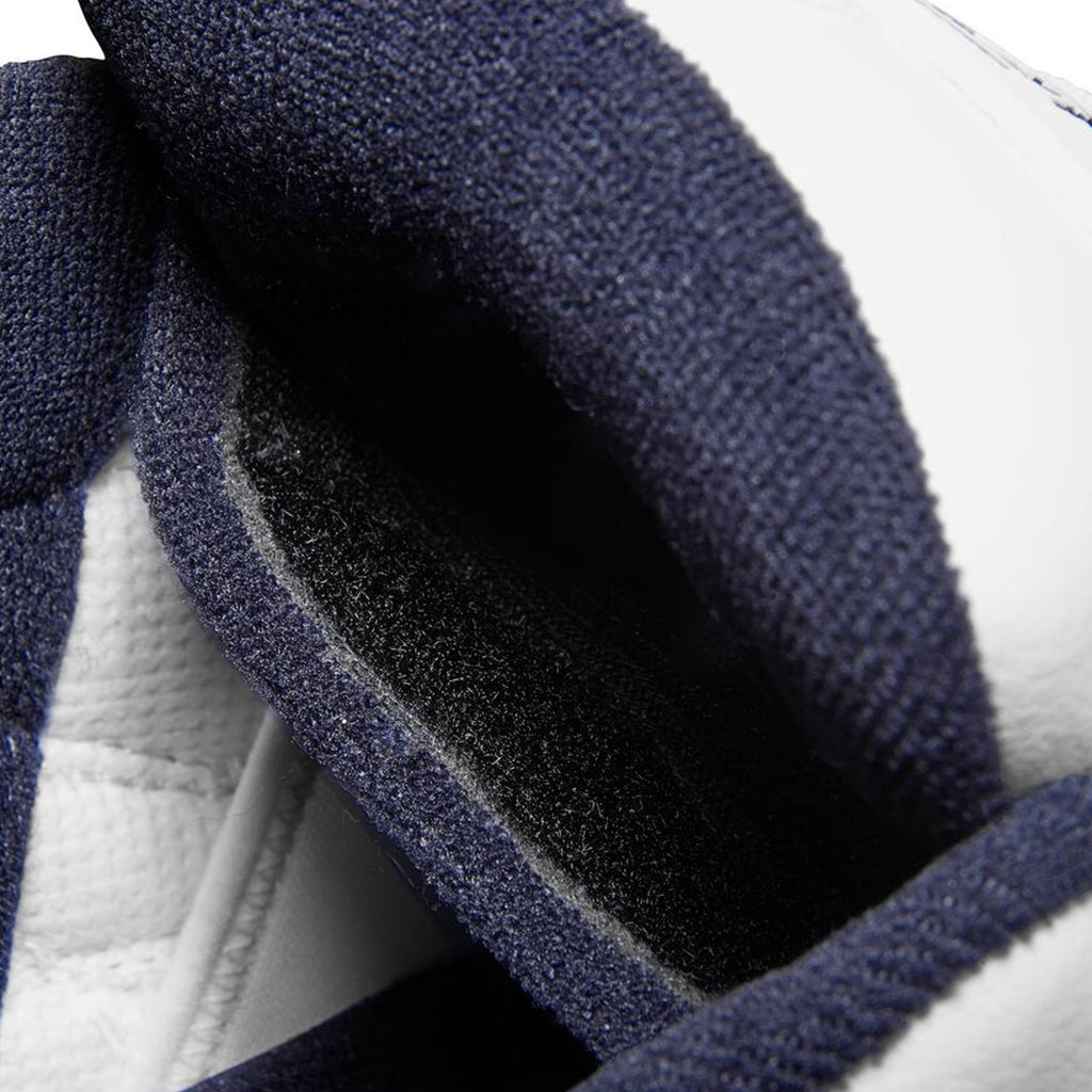A close up of a pair of blue and white skateboarding shoes, known as the ES The Muska White, renowned for their durability and support.