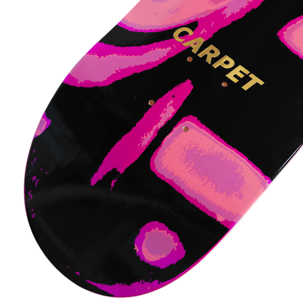 A close-up of the CARPET EGYPT PINK skateboard deck by Carpet Co. against a black background, showcasing abstract pink patterns inspired by Egyptian art and the word "CARPET" elegantly in gold text.