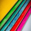 Five FUCKING AWESOME GUN BABY skateboard decks by FUCKING AWESOME are arranged diagonally, each in yellow, green, blue, red, and pink with visible wood grain for an unmistakably bold vibe.