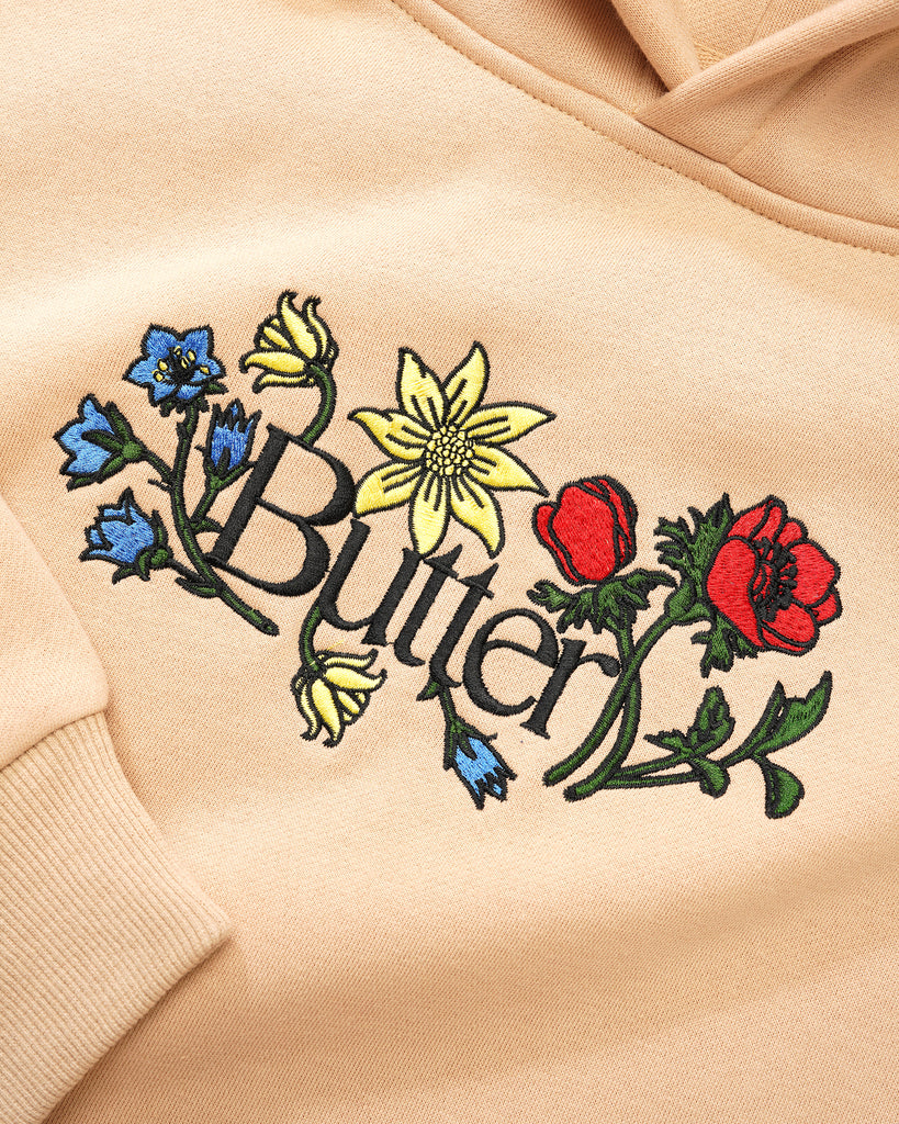 A BUTTER GOODS FLORAL EMBROIDERED HOODIE TAN with the word Butter Goods embroidered on it.