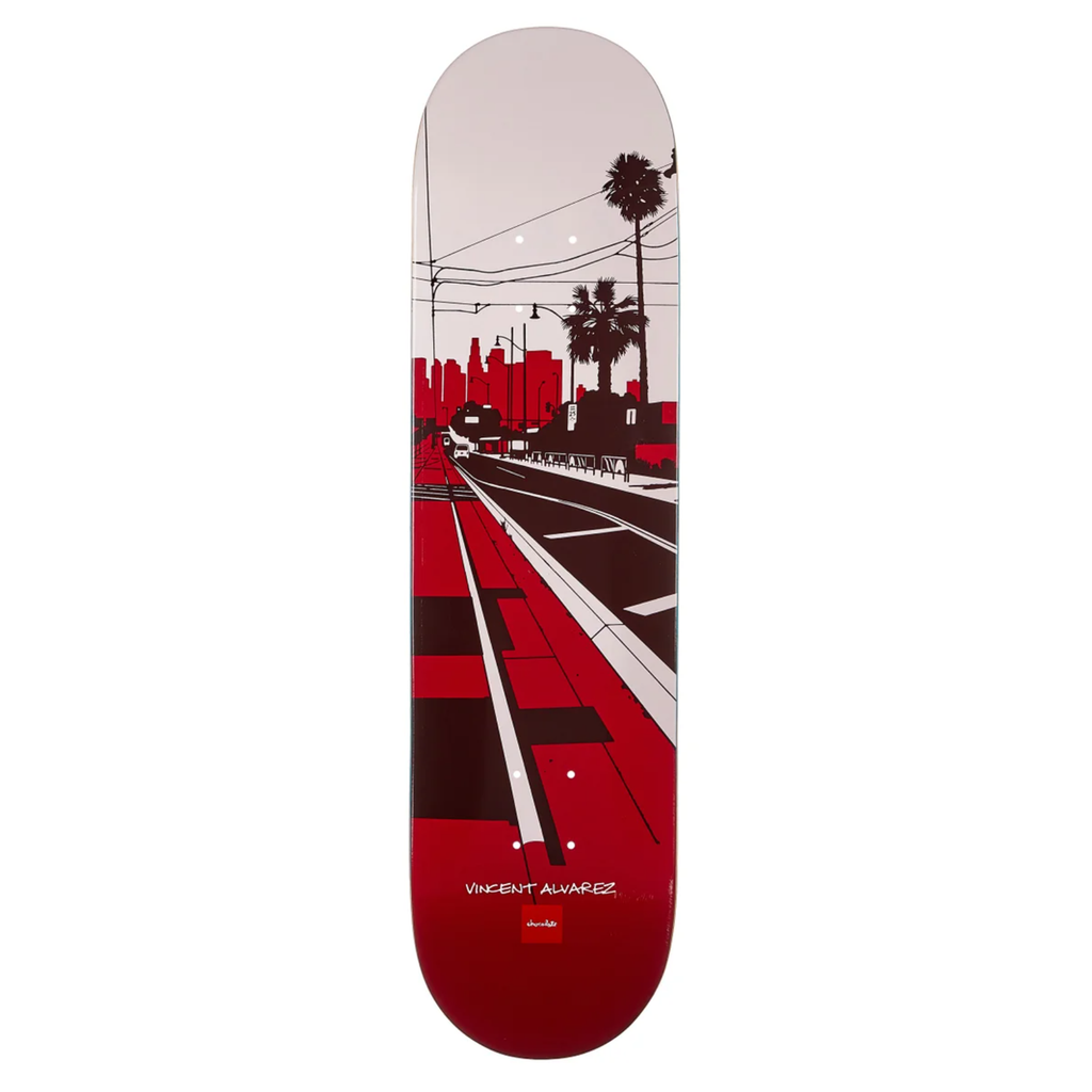 A skateboard deck with a red city scape drawing of a street and some palm trees.