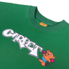 A close up of a green t-shirt with white font that says "Carpet" next to a little bear with boxing gloves.