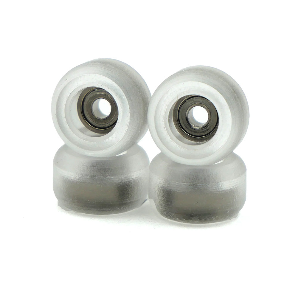 SLUSHCULT GROM FINGERBOARD WHEELS CLEAR by SLUSHCULT are shown stacked in pairs, displaying their transparent design and visible precision bearings against a white background.