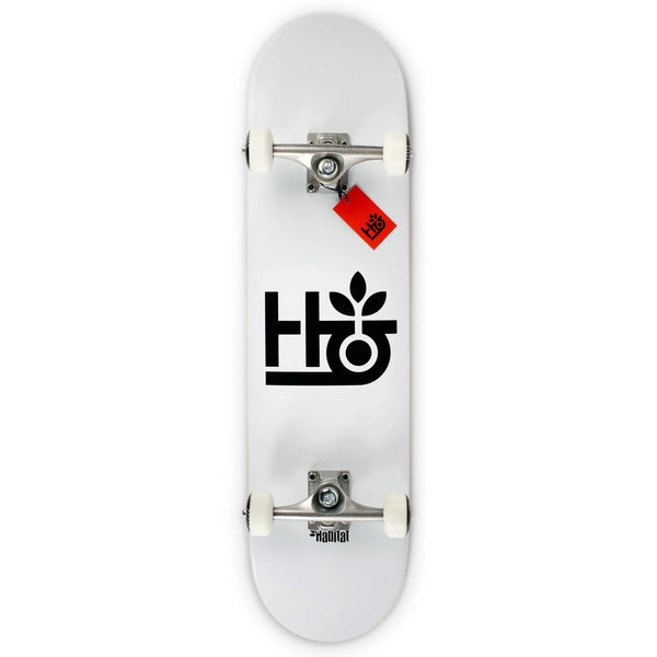 A white HABITAT POD COMPLETE skateboard with black graphics and red bushings on the trucks.