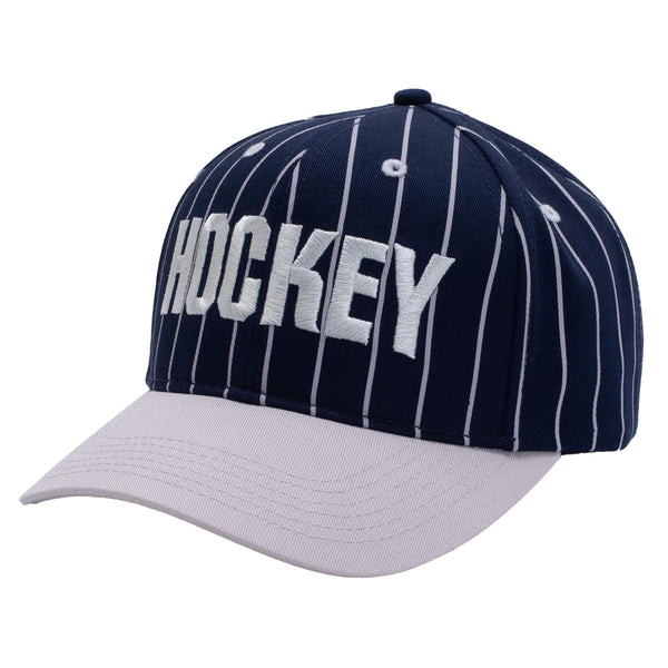 A navy baseball style hat with lilac stripes and brim, with the word "Hockey" embroidered across the front.