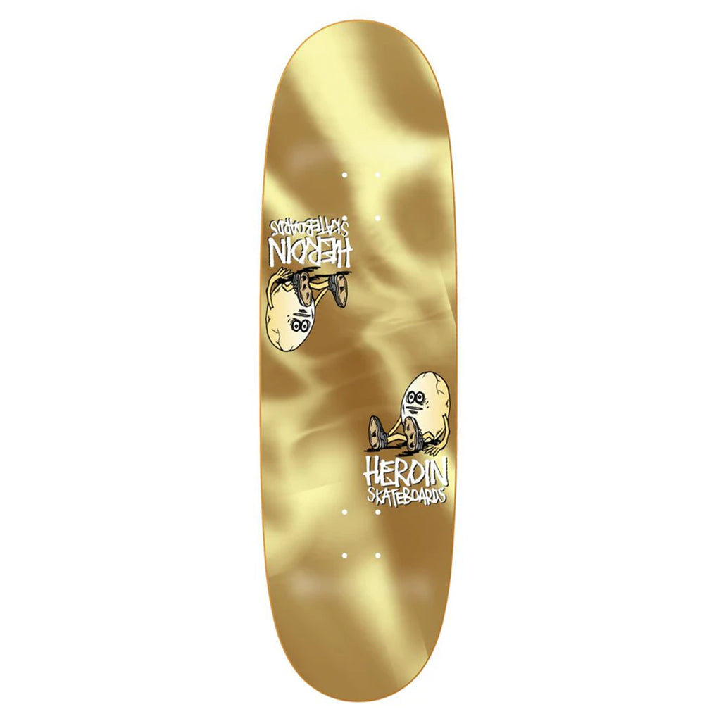 Introducing the HEROIN SYMMETRICAL EGG GOLD FOIL skateboard deck by HEROIN. This board features illustrations of cartoon characters along with the text "Heroin Skateboards" and "Shitfaced Egg." Crafted from hard rock maple, its gold foil finish and symmetrical egg shape promise both durability and style.