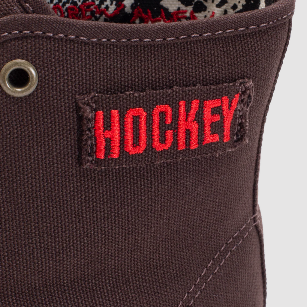 A pair of VANS X HOCKEY SKATE AUTHENTIC HIGH BROWN SNAKE SKIN boots with the word hockey on them.