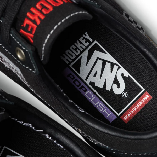 A pair of black VANS X HOCKEY SKATE OLD SKOOL BLACK SNAKE SKIN sneakers with a logo on them.