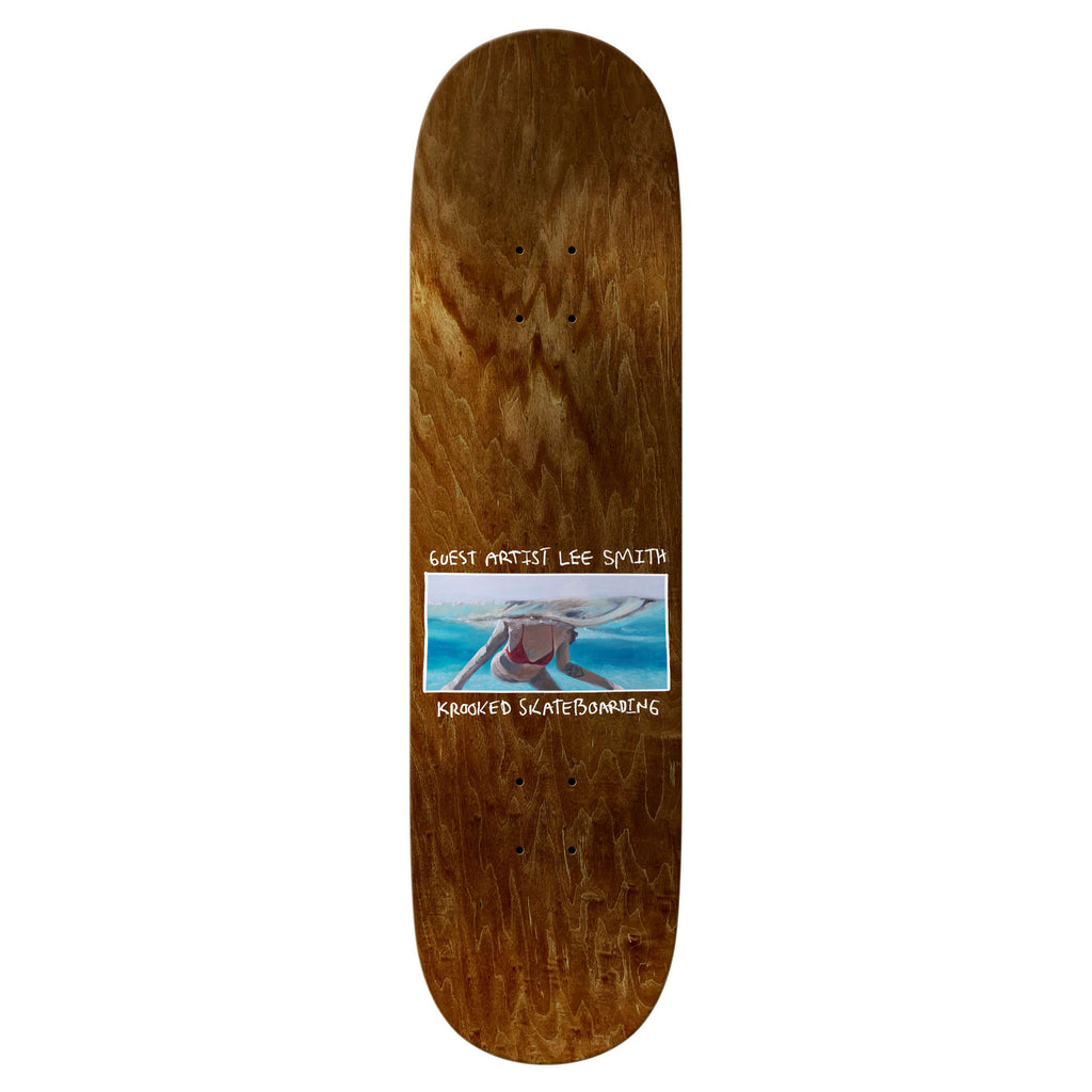 Introducing the KROOKED LEE SMITH GUEST ARTIST WHEEL WELLS skateboard deck, showcasing a brown wood grain pattern with stunning shark artwork by Lee Smith on the bottom. The text "Guest Artist Lee Smith" and "Krooked Skateboarding" is prominently displayed. Designed for quick responsive pop, this deck offers superior control—perfect for KROOKED TEAM EASY RIDERS.