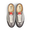 The top view of a pair of grey shoes with a chris milic drawing on the insoles.