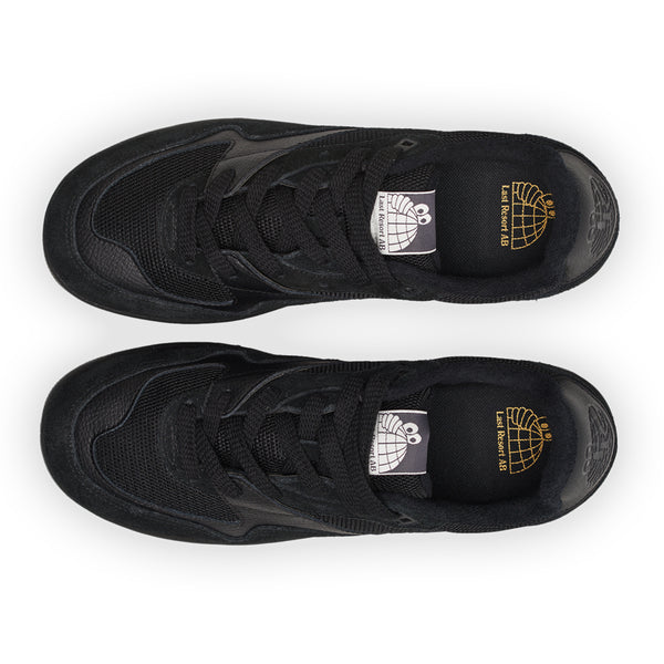 Two black Last Resort AB CM002 sneakers viewed from above, featuring matching laces and decorative designer labels inside.