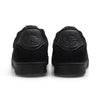 Rear view of the Last Resort AB CM002 black/black leather sneakers with a cartoon face embossed on the heel tabs.