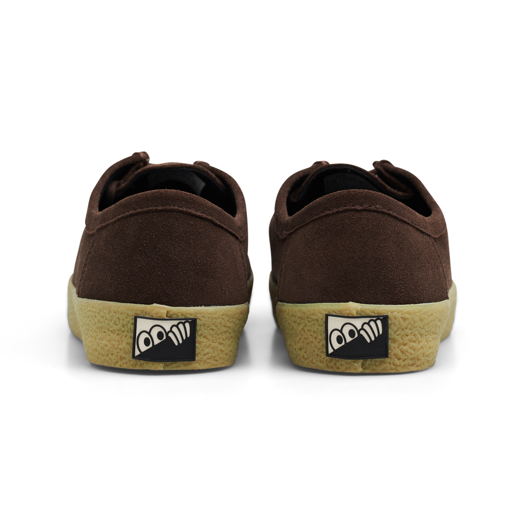 A rear view of the LAST RESORT AB VM006 MOC BROWN / GUM sneakers by Last Resort AB, showcasing brown suede with a beige rubber sole and a logo on the heel.