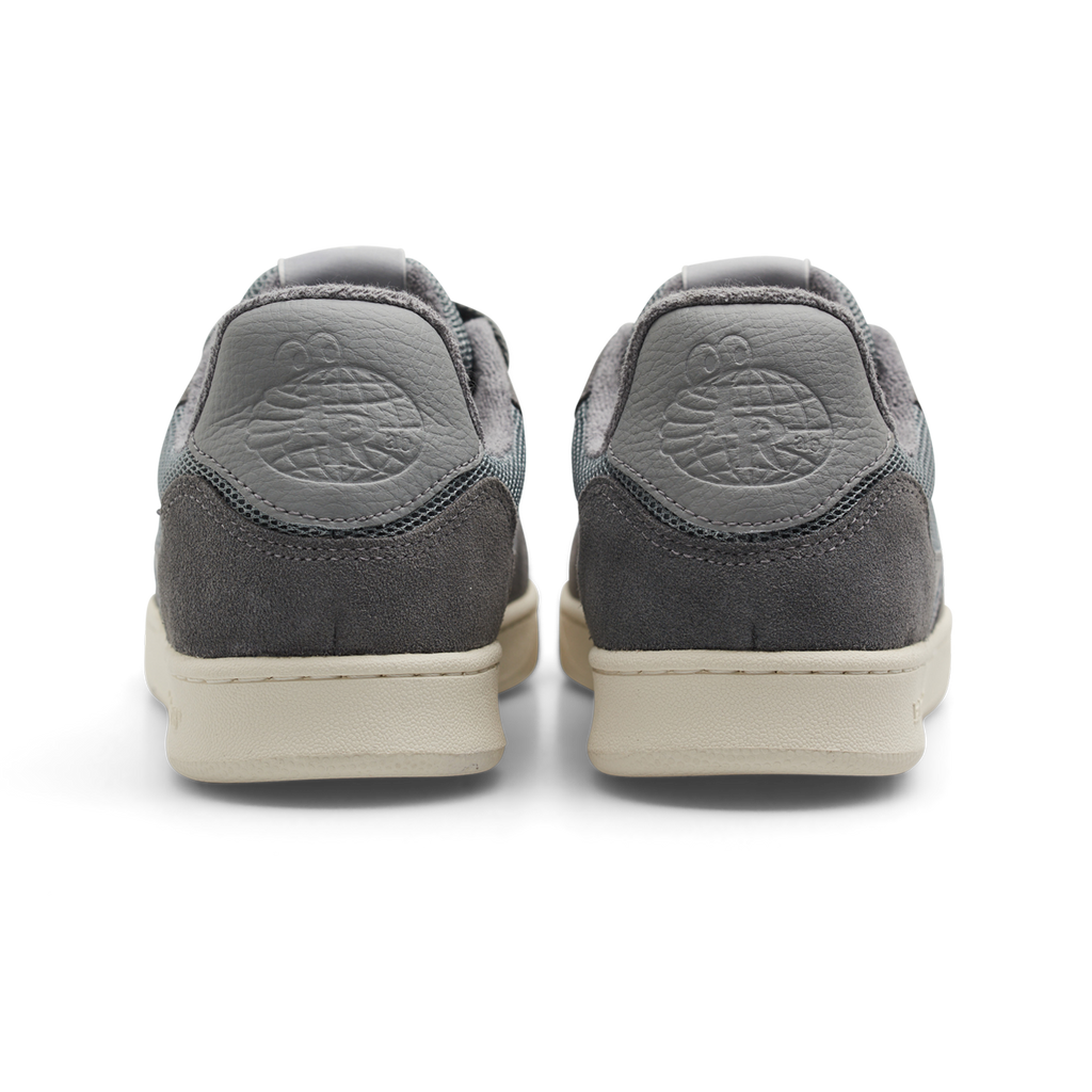 A rear view of the LAST RESORT AB CM002 ULTIMATE GREY sneakers by Last Resort AB showcases their gray suede design with a globe logo on the heel and white soles accented with tactile green.