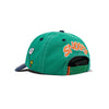 The Butter Goods x Peanuts Music Snapback Cap in washed kelly green/navy features "SNOOPY" embroidered in orange on the back, side cartoon patches, an adjustable strap, and is crafted from comfortable cotton twill.