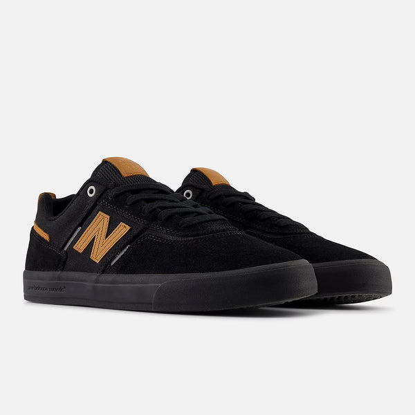 A pair of NB NUMERIC FOY 306 BLACK / BROWN sneakers by NB NUMERIC, featuring black uppers with brown details, displayed at an angle to show the side and front against a plain white background.