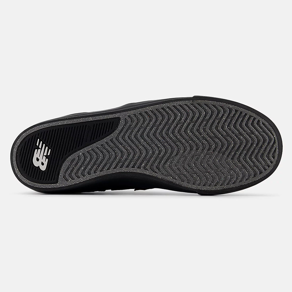 The image shows the black and brown rubber sole of the NB NUMERIC FOY 306 sneaker, with a herringbone tread pattern and NB NUMERIC branding near the heel—a signature detail of this Jamie Foy skate shoe.