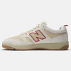 The NB NUMERIC X CHOCOLATE 480 SEA SALT / RED is a tan and cream sneaker featuring a red 'N' logo on the side, gum sole, and reinforced toe cap, evoking the style of 80s and 90s skate shoes.