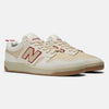 A pair of NB NUMERIC X CHOCOLATE 480 sneakers in a sea salt and red colorway, showcasing the brand's logo and reinforced toe cap, captures the essence of classic 80s and 90s skate shoes, set against a plain background.