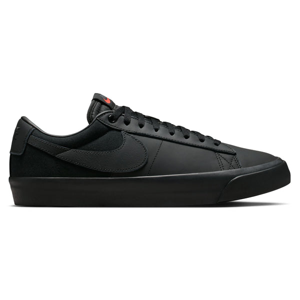 Side view of the NIKE SB BLAZER LOW PRO GT in an all-black colorway, ideal for skateboarding, featuring a swoosh logo on the side and red branding on the tongue, echoing the classic NIKE SB BLAZER style.