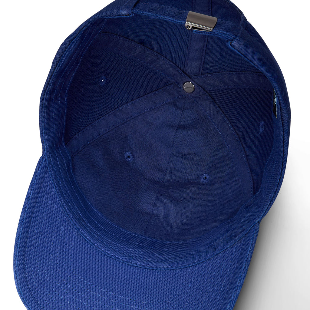 The image showcases the interior of the NIKE SB CLUB HAT BLUE VOID/GAME ROYAL, featuring meticulous stitching and a metal adjustment clasp, all crafted from premium cotton twill.