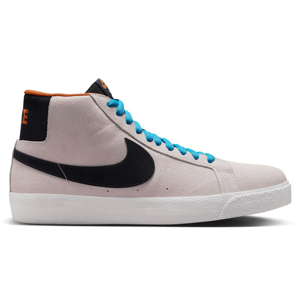 Side view of a high-top NIKE SB Zoom Blazer Mid Electric Phantom/Black-Monarch-Summit White sneaker in light grey suede with a black swoosh, blue laces, and an orange inner lining. The shoe has a white textured rubber sole and features Zoom Air cushioning for ultimate comfort.