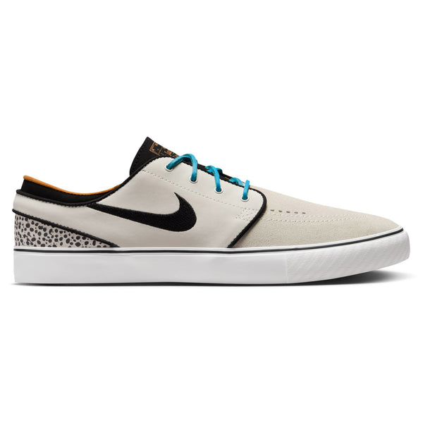 A single NIKE SB Zoom Janoski OG+ sneaker, branded by Nike, featuring an Electric Phantom and Chlorine Blue color scheme with a black swoosh logo, blue laces, and a white sole. The skateboarding shoe also showcases a beige and black upper adorned with leopard print detail on the heel and equipped with Zoom Air cushioning for ultimate comfort.