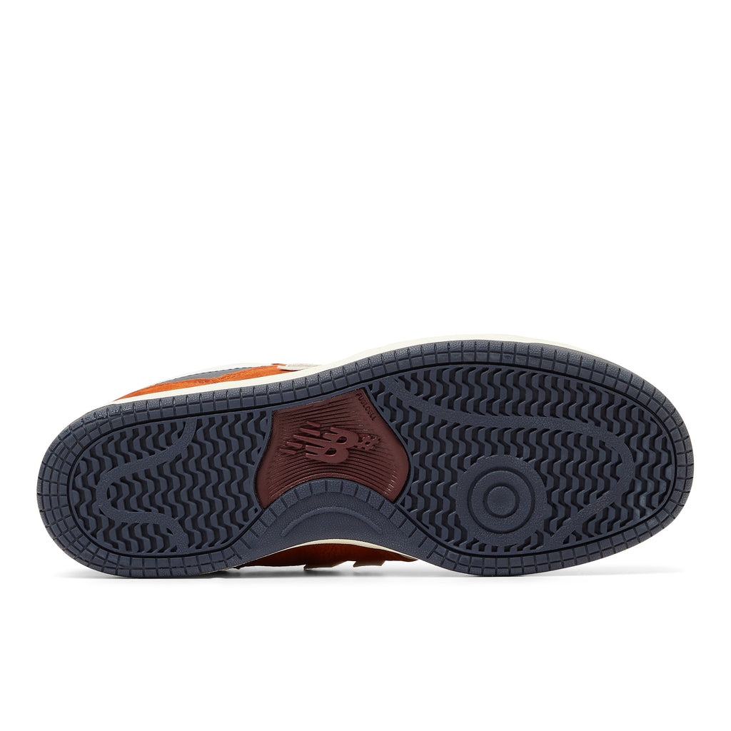 The back of a NB NUMERIC 480 BROWN / WHITE sneaker in orange and black.